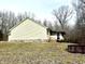 View of a light yellow ranch style home with a screened in porch, surrounded by bare trees at 1195 Hinson Rd, Martinsville, IN 46151
