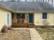 Charming yellow house with a welcoming front porch, blue door and walkway to the entrance at 1195 Hinson Rd, Martinsville, IN 46151