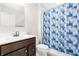 Bright bathroom featuring a modern vanity, mirror, and shower with colorful patterned curtain at 1230 Maumee Ct, Greenfield, IN 46140