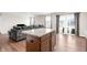 Open-concept kitchen with a granite island flowing into a living space with multiple windows at 1230 Maumee Ct, Greenfield, IN 46140