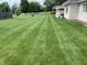 Lush backyard with a perfectly striped lawn, and patio, offering ample space for outdoor activities at 1434 Manchester Dr, Danville, IN 46122