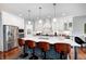 Modern kitchen with an island, bar stool seating, stainless steel appliances, and custom cabinetry at 1434 Manchester Dr, Danville, IN 46122