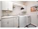 Functional laundry room with white cabinets, sink, and modern washer and dryer at 1434 Manchester Dr, Danville, IN 46122