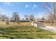 Spacious backyard with a grassy lawn, mature trees, and a detached garage at 1780 S Mauxferry Rd, Franklin, IN 46131
