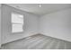 Bright bedroom features gray carpet, white walls, and a view from the window at 1950 Black Oak Dr, Shelbyville, IN 46176