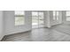 Bright living room with gray vinyl floors, sliding glass doors and large windows offering scenic outdoor views at 1951 Black Oak Dr, Shelbyville, IN 46176
