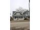 Attractive gray home featuring a covered porch with decorative columns and a well-maintained lawn at 21 S Warman Ave, Indianapolis, IN 46222