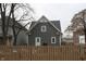 Two-story home with gray siding and white trim, set behind a wooden fence and mature trees at 21 S Warman Ave, Indianapolis, IN 46222