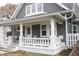Attractive gray home featuring a covered front porch with decorative white columns at 21 S Warman Ave, Indianapolis, IN 46222