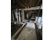 A gutted room with exposed floor joists, unfinished walls, and natural light streaming through the window frames at 21 S Warman Ave, Indianapolis, IN 46222