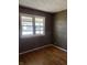 Bedroom featuring hardwood floors, neutral walls, a window overlooking the neighborhood and textured ceiling at 251 S 12Th Ave, Beech Grove, IN 46107