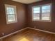 Bedroom with hardwood floors, two large windows, and brown paint at 251 S 12Th Ave, Beech Grove, IN 46107