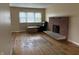 Cozy living room featuring a brick fireplace, hardwood floors, and ample natural light at 251 S 12Th Ave, Beech Grove, IN 46107