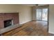 Bright living room featuring hardwood floors, brick fireplace, and access to the backyard at 251 S 12Th Ave, Beech Grove, IN 46107
