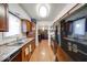 Galley kitchen with wood-look floors, granite counters, brown cabinets, and updated appliances at 2552 Spring Hill Ct, Indianapolis, IN 46268