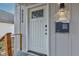 Close-up of the front door featuring new hardware, a modern mailbox, and a stylish exterior light fixture at 2626 E 18Th St, Indianapolis, IN 46218