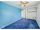Bedroom with a bright blue accent wall, carpeted floors and ceiling fan at 2714 Manlove Ave, Indianapolis, IN 46218
