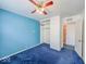 Bedroom with blue accent wall, carpeted floors, closet and view to another room at 2714 Manlove Ave, Indianapolis, IN 46218
