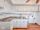 Close up of kitchen area featuring white cabinets, laminate countertops, and wood look vinyl floors at 2714 Manlove Ave, Indianapolis, IN 46218