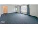 Large living room displaying neutral paint, carpet, and a front door at 2714 Manlove Ave, Indianapolis, IN 46218