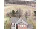 An aerial view shows a brick home with a prominent gabled roof and surrounding landscape at 2879 Bluewood Way, Plainfield, IN 46168