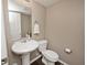 Well-lit half bathroom featuring a pedestal sink, toilet, and neutral color scheme at 2879 Bluewood Way, Plainfield, IN 46168