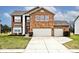 Inviting two-story brick home features a well-maintained lawn and attached two-car garage at 2879 Bluewood Way, Plainfield, IN 46168