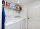Efficient laundry room with white washer and dryer, and shelving for storage of supplies at 2879 Bluewood Way, Plainfield, IN 46168