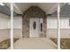 Close-up of the front entrance with stone accents, decorative pillars, and a stylish front door with oval glass at 32 Downing Dr, Trafalgar, IN 46181