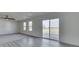 Spacious living room features gray carpet and a sliding glass door that leads to a deck at 32 Downing Dr, Trafalgar, IN 46181