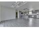 Spacious open-concept living room with modern gray tones, tray ceiling, luxury vinyl floors, and kitchen access at 32 Downing Dr, Trafalgar, IN 46181