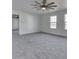 Open main bedroom features neutral carpet, ceiling fan, and large windows for plenty of natural light at 32 Downing Dr, Trafalgar, IN 46181