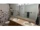 Well-lit bathroom featuring a double sink vanity, floral patterned shower curtain, and neutral tones at 3766 N Lakeside Dr, Muncie, IN 47304
