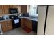 Traditional kitchen with wood cabinets, black appliances, and sink view of the backyard at 3766 N Lakeside Dr, Muncie, IN 47304