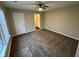 Spacious carpeted bedroom with a ceiling fan, window, and an open bathroom doorway at 3837 Candle Berry Dr, Indianapolis, IN 46235