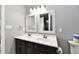 Well-lit bathroom featuring a double sink vanity with dark cabinets and stylish mirrors at 3873 Crest Point Dr, Noblesville, IN 46062