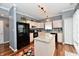 Well-lit kitchen with an island, granite countertops, black appliances, and light pink cabinets at 3873 Crest Point Dr, Noblesville, IN 46062