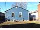 This exterior shows the home's blue vinyl siding and white window trim with a partially fenced yard at 4113 Fletcher Ave, Indianapolis, IN 46203