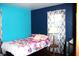 Bright bedroom with a bed, a lamp on a table, and a colorful blue wall at 4113 Fletcher Ave, Indianapolis, IN 46203