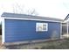 This exterior shot shows a one-story home with blue siding and a gray roof against a bright blue sky at 4113 Fletcher Ave, Indianapolis, IN 46203