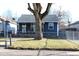 A charming one-story house with a fenced yard and a mature tree providing shade at 4113 Fletcher Ave, Indianapolis, IN 46203