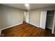 Neutral bedroom showcases gleaming hardwood floors, a large closet, and easy access to the hallway at 4616 N Kenmore Rd, Indianapolis, IN 46226