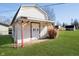 Charming outbuilding with red accents, double doors, brick paver entrance, and green lawn at 4812 Southview Dr, Anderson, IN 46013