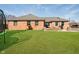 Well-manicured lawn and brick exterior in this expansive backyard view at 5079 Stonespring Way, Anderson, IN 46012
