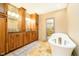 Elegant bathroom with dual vanities, beautiful cabinets, granite countertops, and a freestanding tub at 5079 Stonespring Way, Anderson, IN 46012
