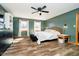 Bright bedroom with a ceiling fan, natural light, modern décor, wood-look floors and green walls at 5079 Stonespring Way, Anderson, IN 46012