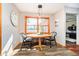 Cozy dining area features a charming table, stylish chairs, a rustic wood frame window and wood floors at 5079 Stonespring Way, Anderson, IN 46012