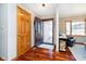 Inviting foyer with hardwood floors, open door with decorative glass, and a view into the living area at 5079 Stonespring Way, Anderson, IN 46012