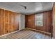 A view of a bedroom showcasing wood paneling, a window, and unique carpeting at 7016 Evanston Ave, Indianapolis, IN 46220