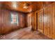 Cozy bedroom featuring wood paneling, natural light, and ample space for storage at 7016 Evanston Ave, Indianapolis, IN 46220